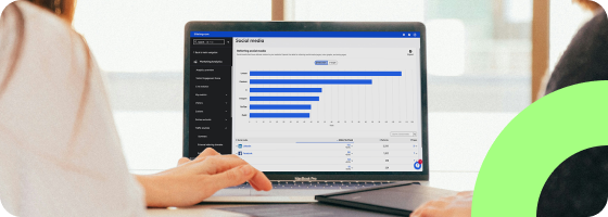 A person using a computer. The Social Media dashboard of the Siteimprove platform is showing on the screen.