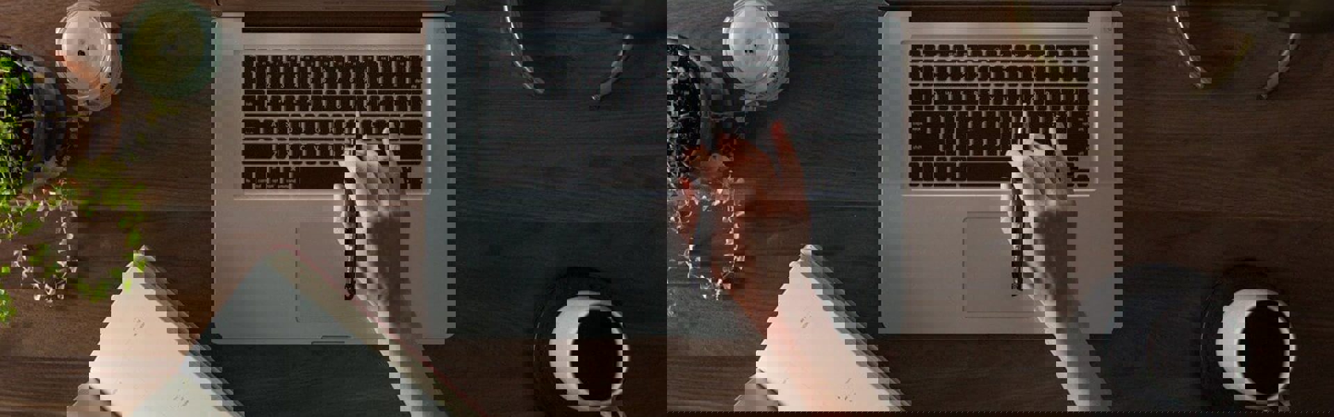 Person typing on laptop while looking at notes for Helvetica case study.