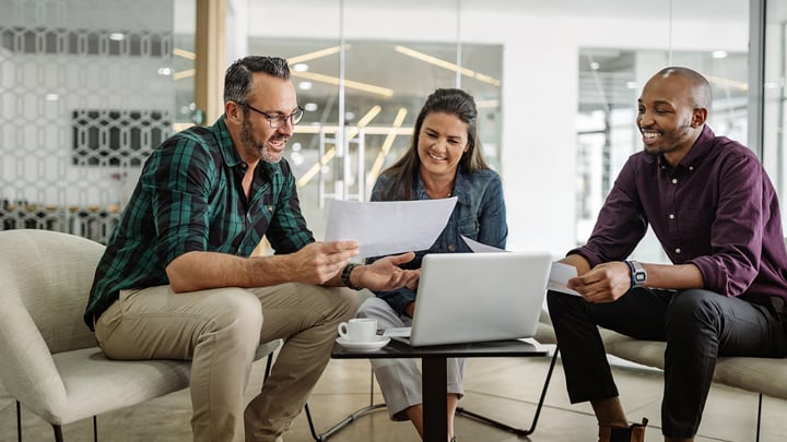 Group of people looking at their finaces on a paper and laptop.