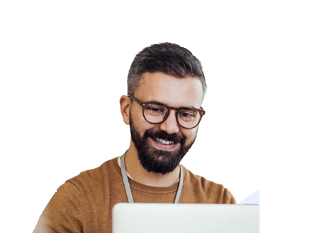 Guy looking at a computer smiling.